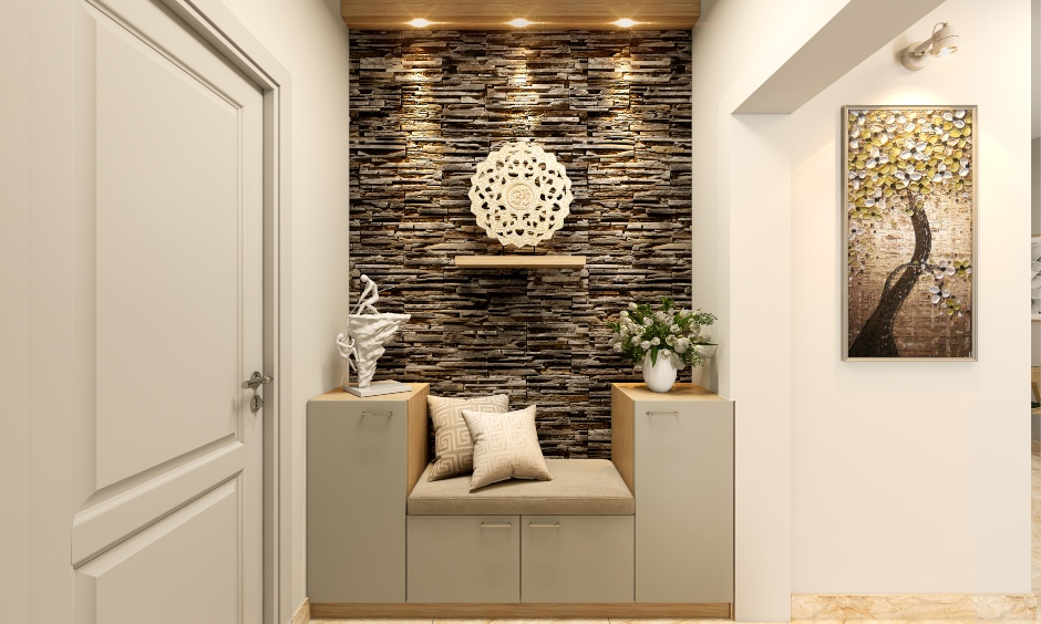 1 bhk flat foyer designed with a stone-cladding accent wall and seats and storage lend an uber-cool look