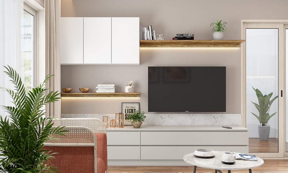 A tv unit with pull to open drawers and overhead cabinets in white for a 3bhk flat interior design