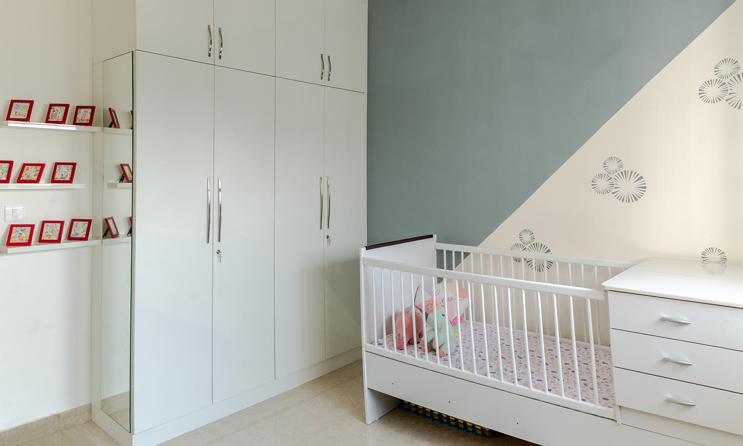 Baby room with a cot and cabinet designed by design cafe which is one of the top interior designers in bangalore