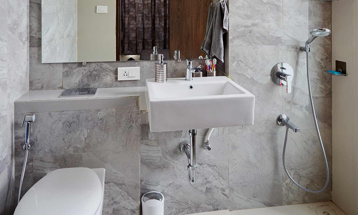 Bathroom design with grey tiles designed by interior design company in mumbai