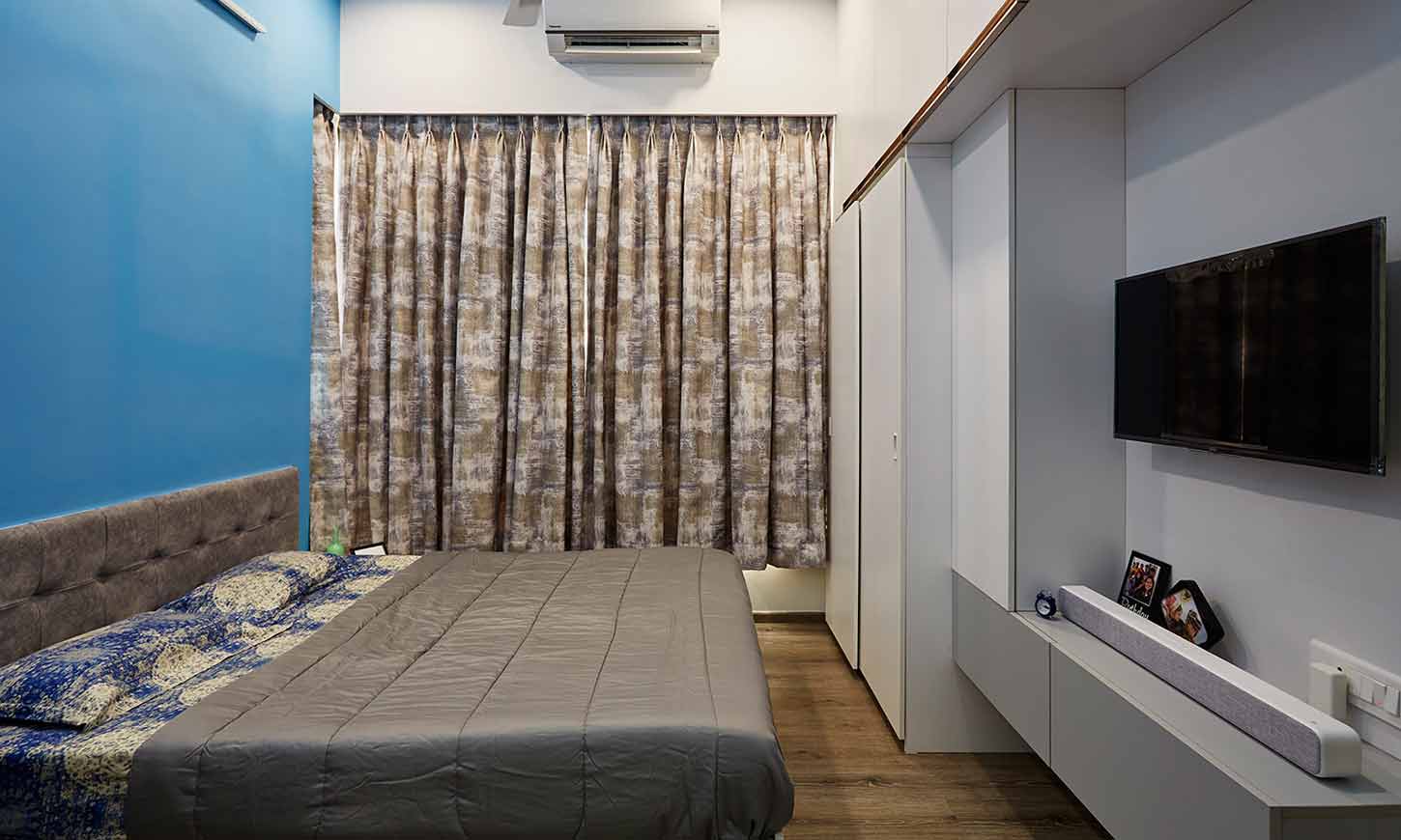 Bedroom designer in mumbai with wall mounted bedroom cupboards and a tv unit