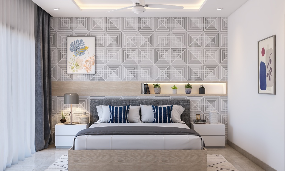 1 bhk bedroom features a geometric wallpaper and bed with cushioned headboard in 1 bhk flat design