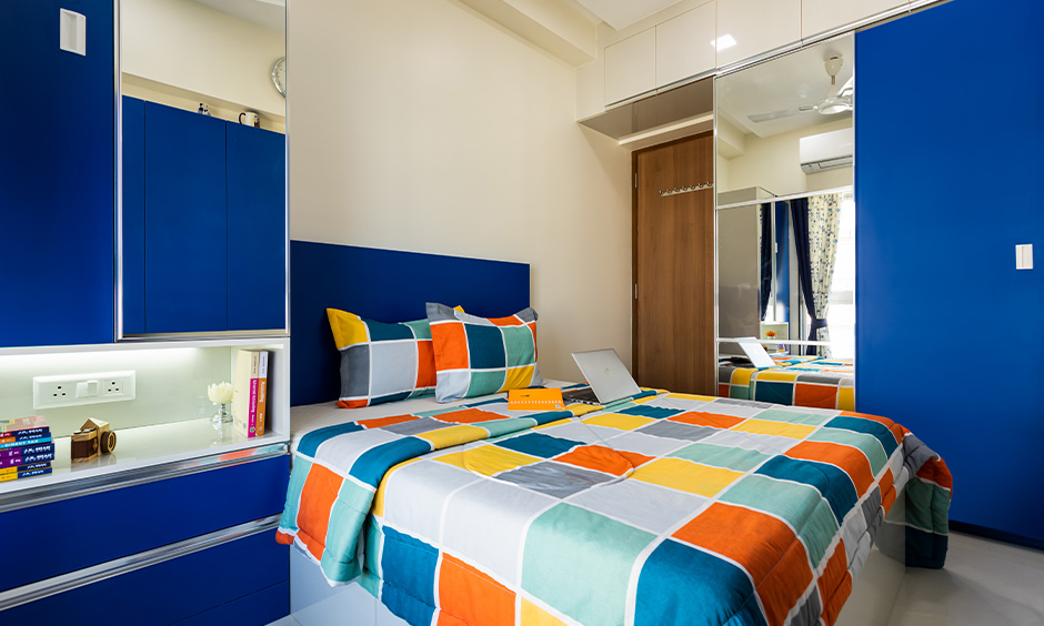 A blue bedroom with study table and wardrobe designed by one of the best home interior designer in mumbai