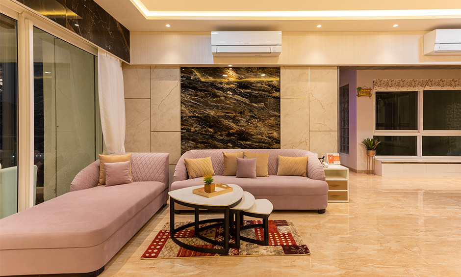 Best residential interior designers in mumbai where a lively, bright living room with an elegant pink sofa and chaise lounge set