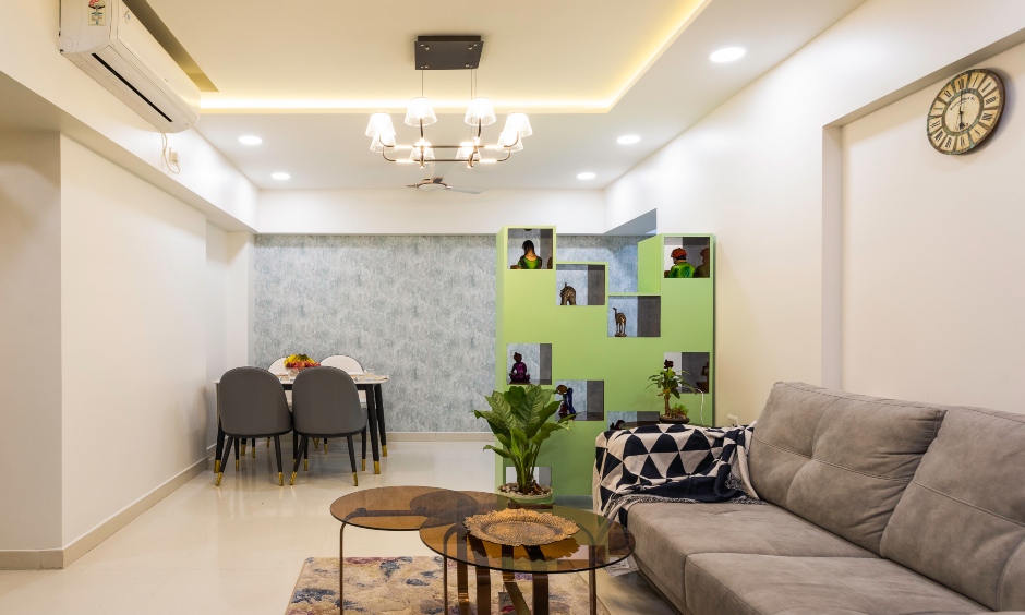 Living cum dining room is designed with a sectional sofa, a four-seater dining table by budget interior designers in mumbai