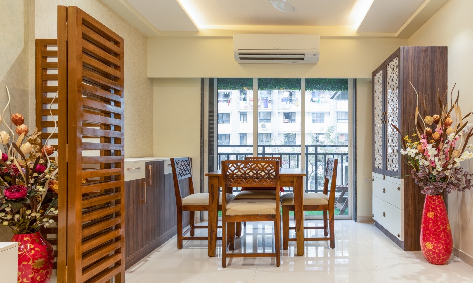 Dining room with a wooden table and cushioned chairs designed by best interior decorators in mumbai