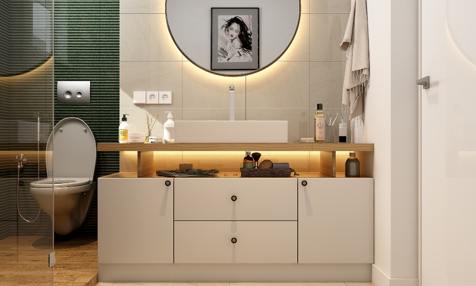 Green and white 2bhk bathroom designed with wall mirror and vanity unit to arrange toiletries for a clutter-free look