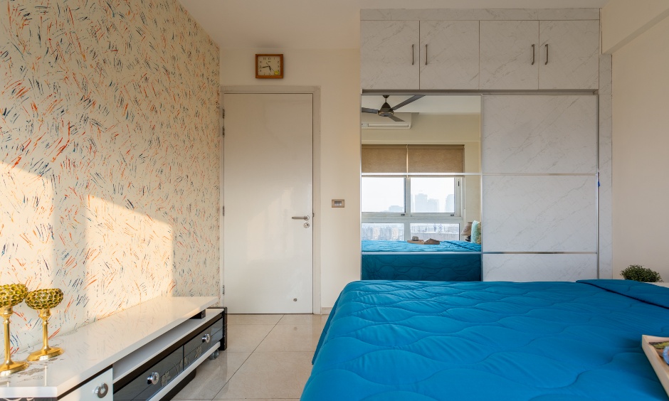A grey sliding wardrobe comes with loft storage designed by interior designers in Mumbai