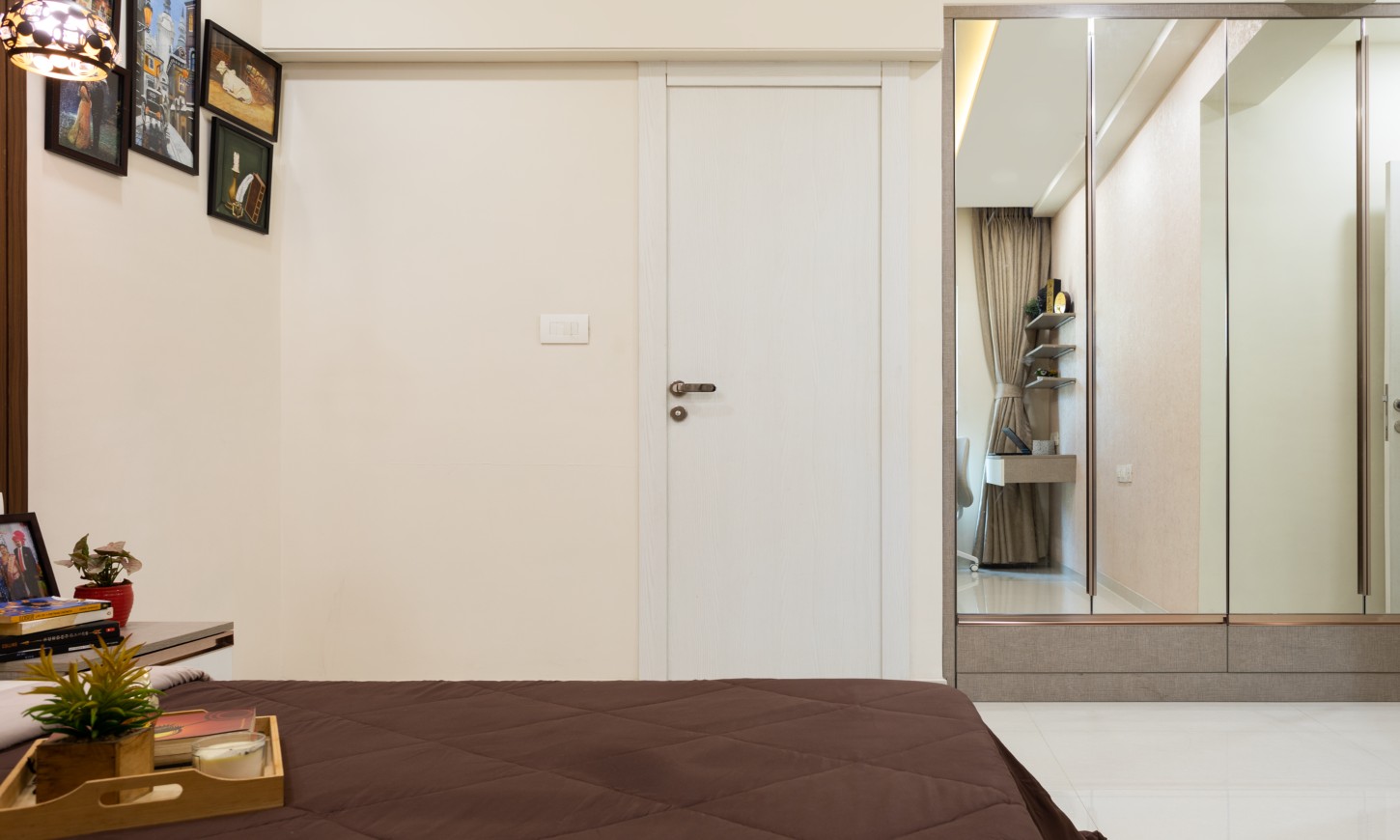 2 bhk apartment in Thane West features a guest bedroom with a mirrored wardrobe designed by a top interior designer