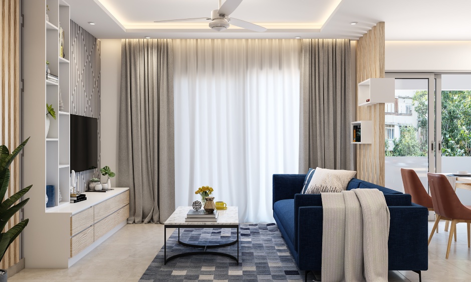 Living room design with sofa and false ceiling with cove lights in 1 bhk flat lends a luxurious vibe to the space