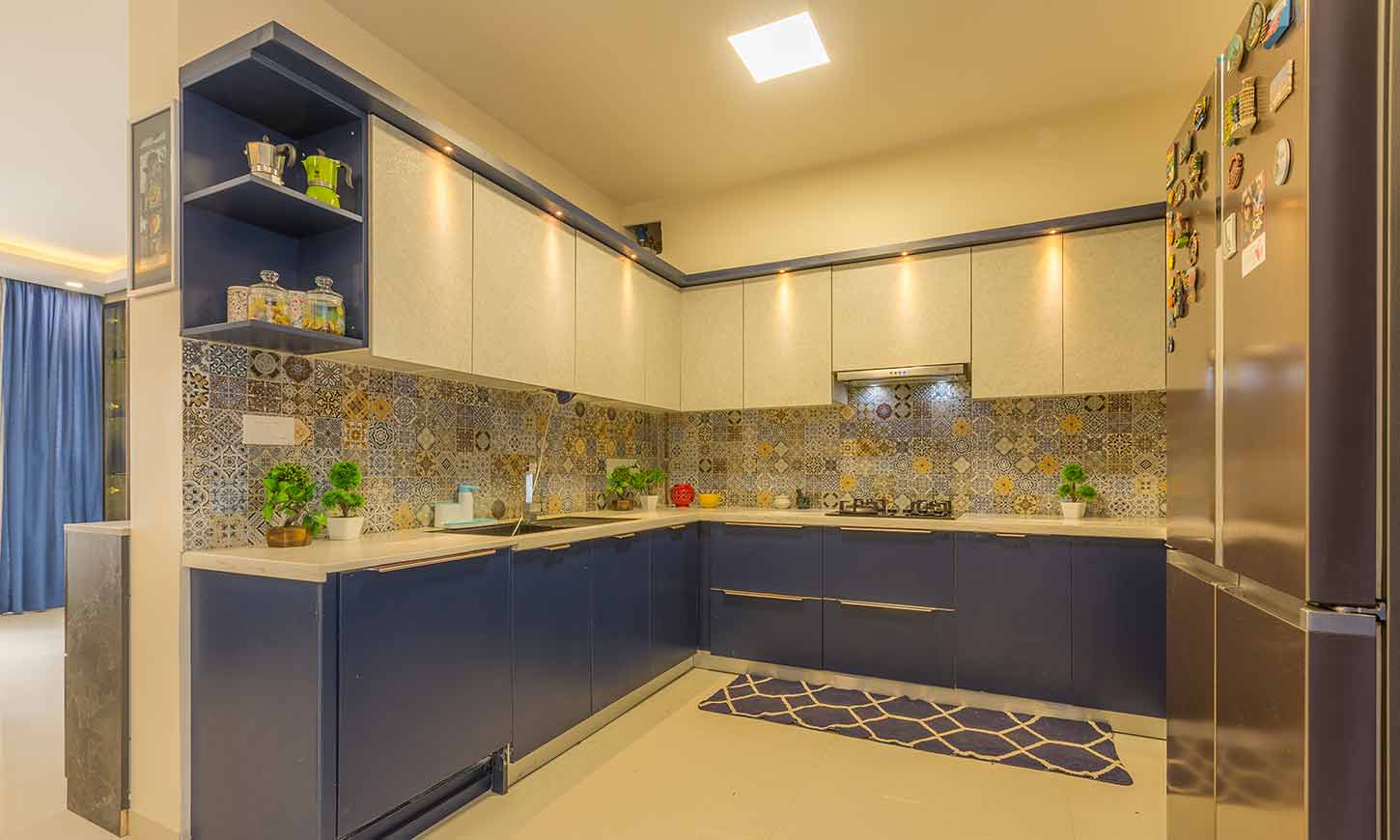 Modular kitchen price in bangalore with a blue and white kitchen designed by design cafe mg road