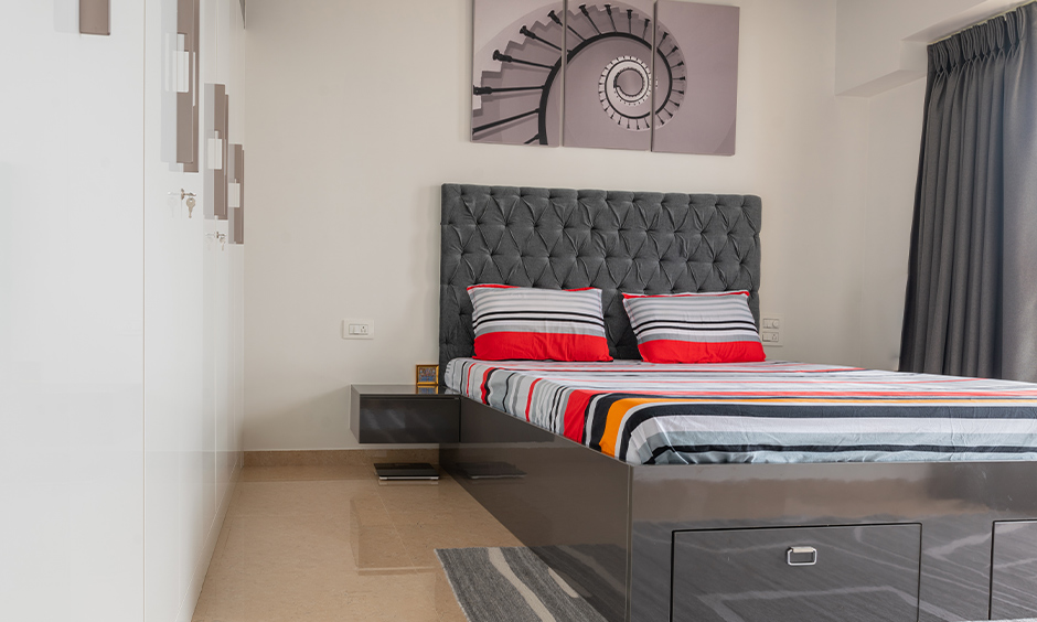 mumbai flat interior designed with a bed and a bedside table with wardrobes in the front