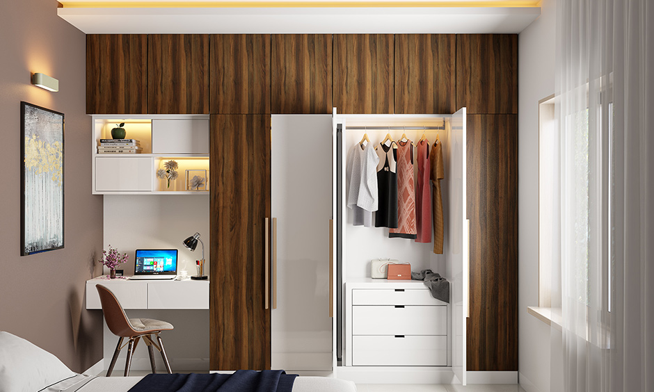 Shutter kids wardrobe with study table and bookshelf design is simple yet striking with a bold wood grain laminate.