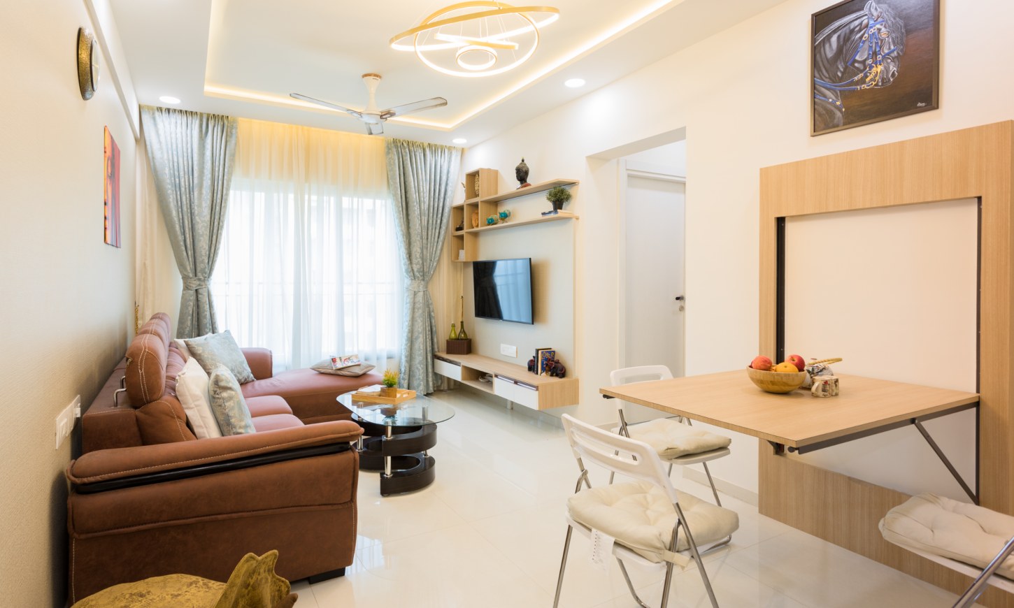 Designcafe interior designer in Wajiwada, Thane, designed a white living room with a wall-mounted TV unit